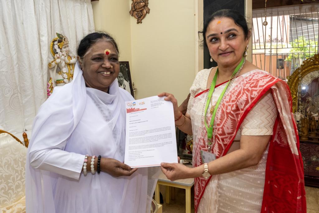 Mata Amritanandamayi standing with Dr. Sandhya Purecha